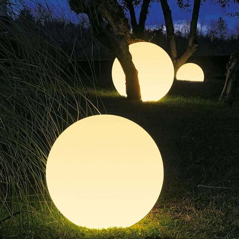 Elif Globe Outdoor Lights illuminating garden at night