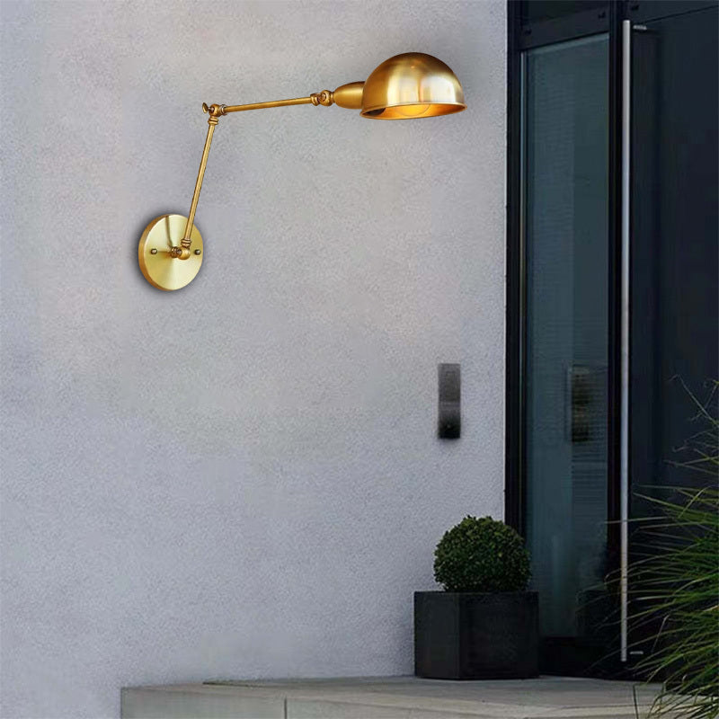 Bronze swing arm wall lamp on gray wall.