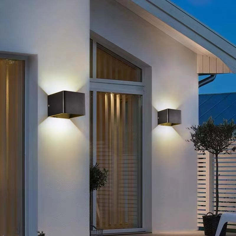 Orr square LED outdoor wall lamp lighting a white wall.