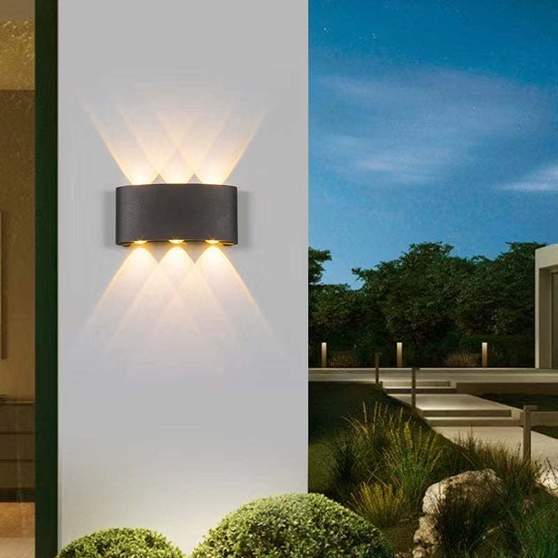 Modern metal outdoor wall lamp illuminating garden