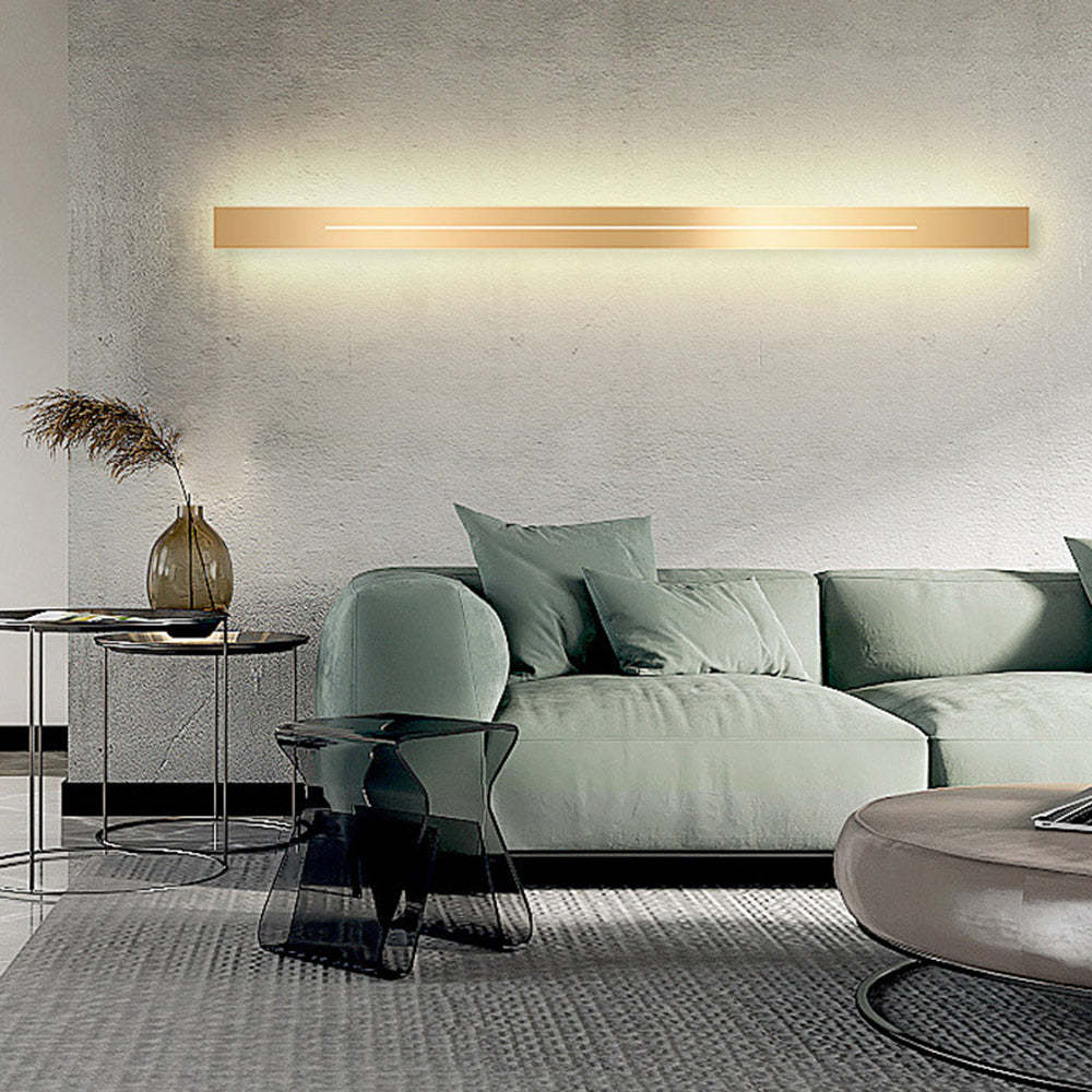 Modern gold LED wall lamp above green sofa, Lassola lighting