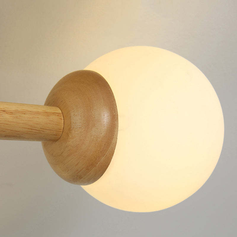 Ozawa dimmable ceiling light with wooden arm and glass globe.
