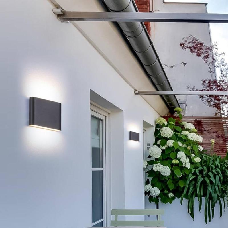 Modern black outdoor wall lamps illuminating garden