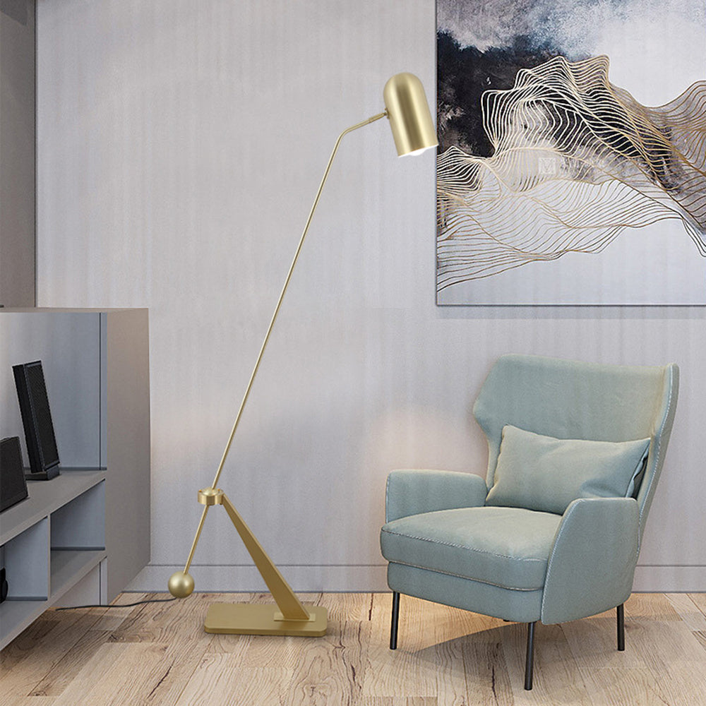 Brass floor lamp illuminating living room with armchair - Lassola Lighting