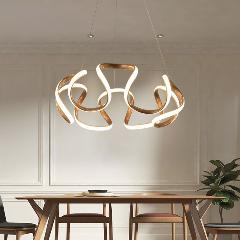 Louise pendant light in gold over dining table. Modern lighting fixture.