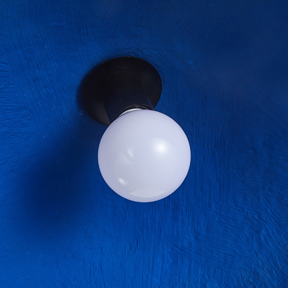 Close-up of Hailie Pendant Light bulb, blue background