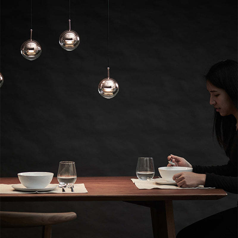 Modern dining room with Valentina pendant lights and a woman eating