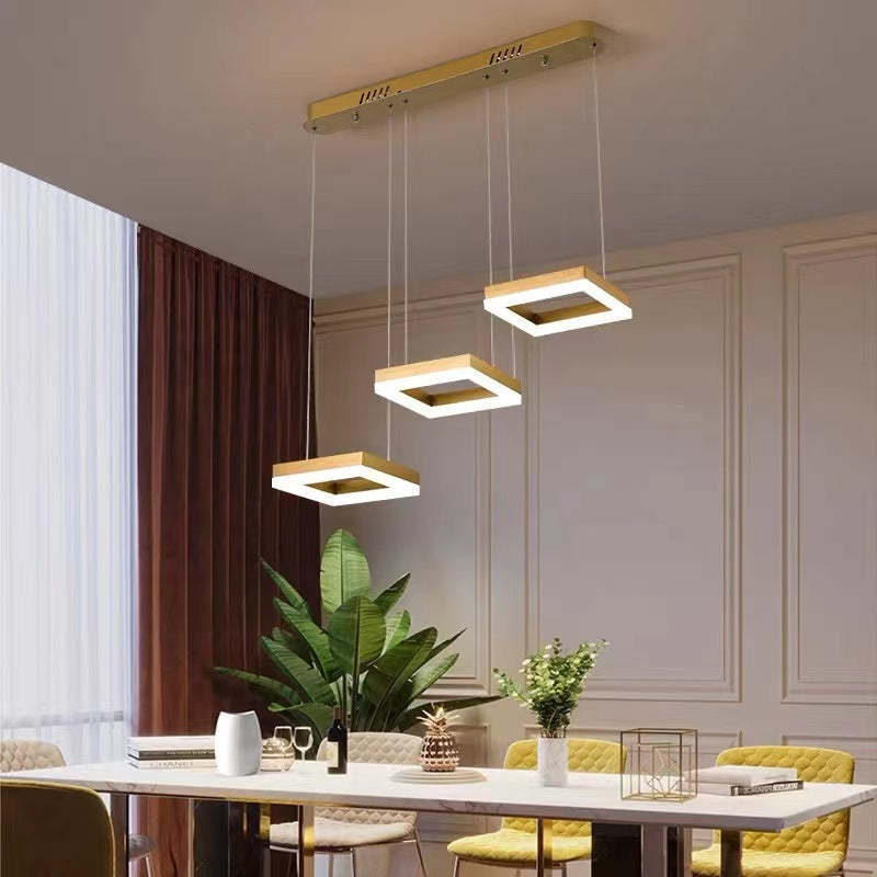 Modern gold pendant light fixture above dining table