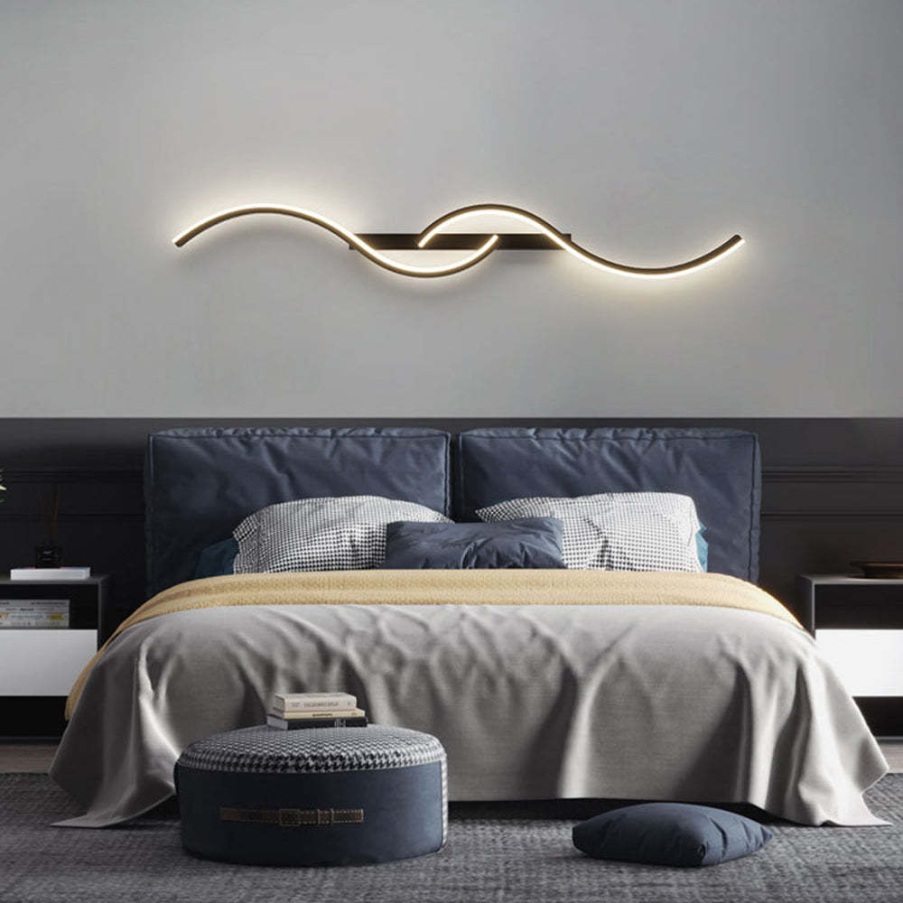 Louise modern wave wall lamp in a styled bedroom setting.