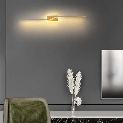 Modern minimalist wall lamp with gold finish in a living room.