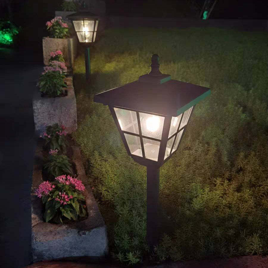 Pena Modern Bollard Light illuminating a garden at night