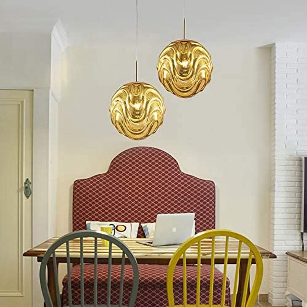 Gold sphere pendant lights above a dining table