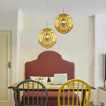 Gold sphere pendant lights above a dining table
