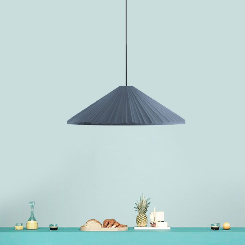 Gray triangle pendant light above dining setup. Nordic style lighting.