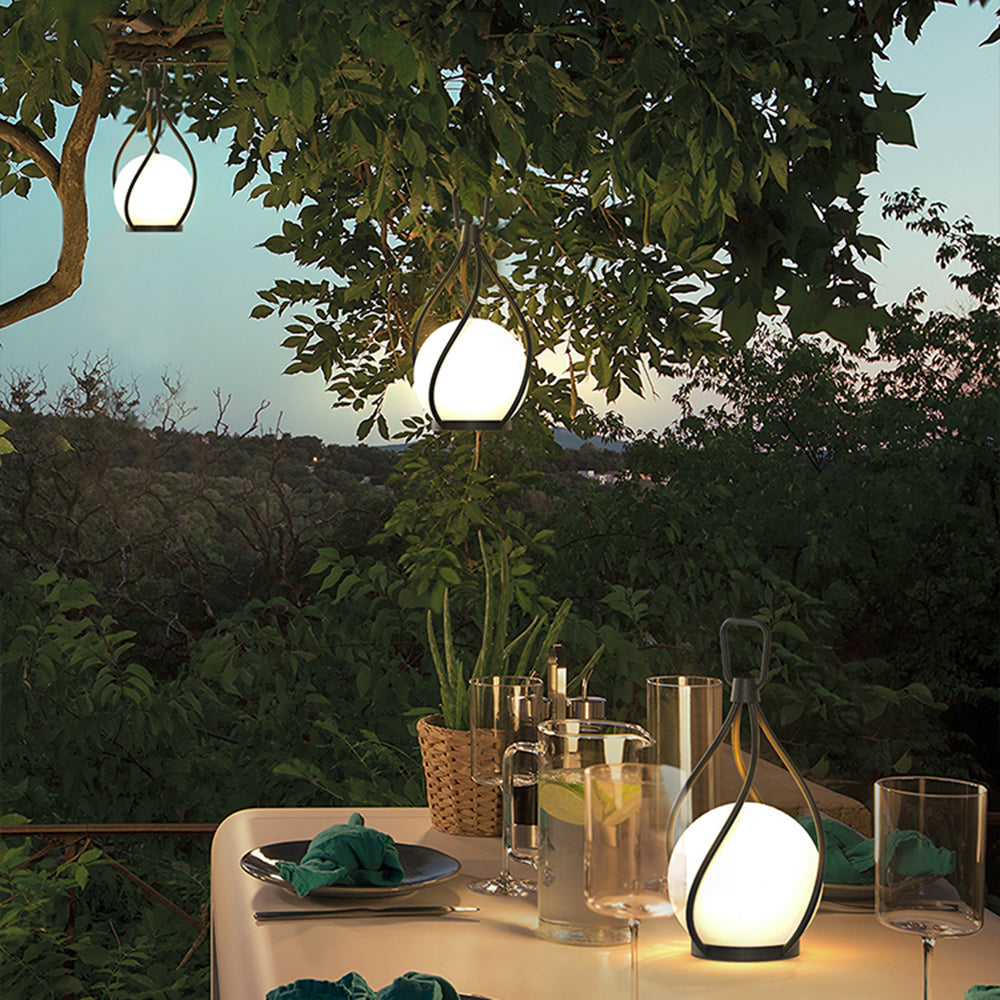 Outdoor dining scene with Valentina pendant lights, enhancing garden ambiance.