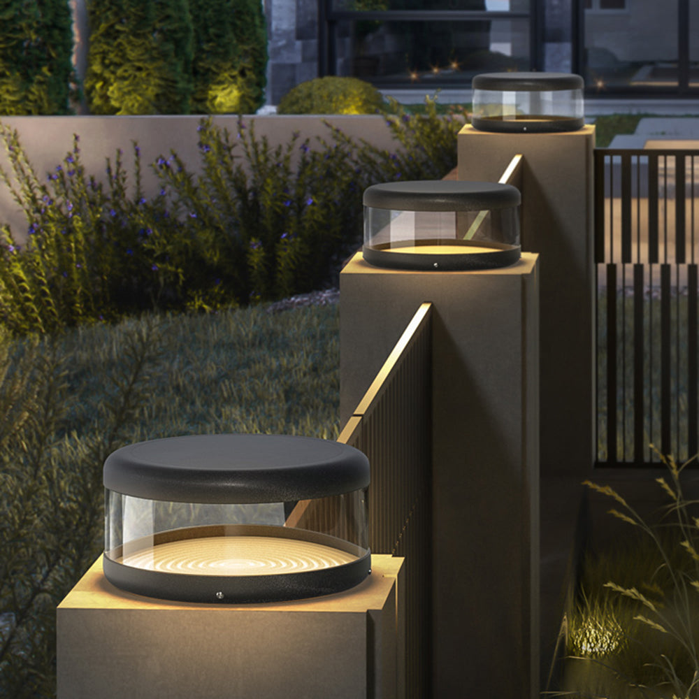 Riley Modern Cylinder Outdoor Pillar Lights illuminating a garden