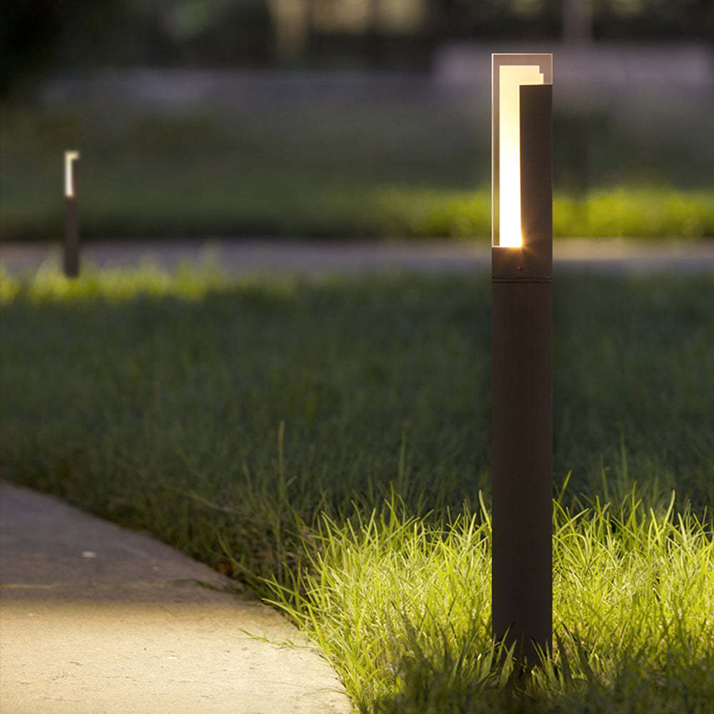 Modern outdoor path light illuminating a garden walkway
