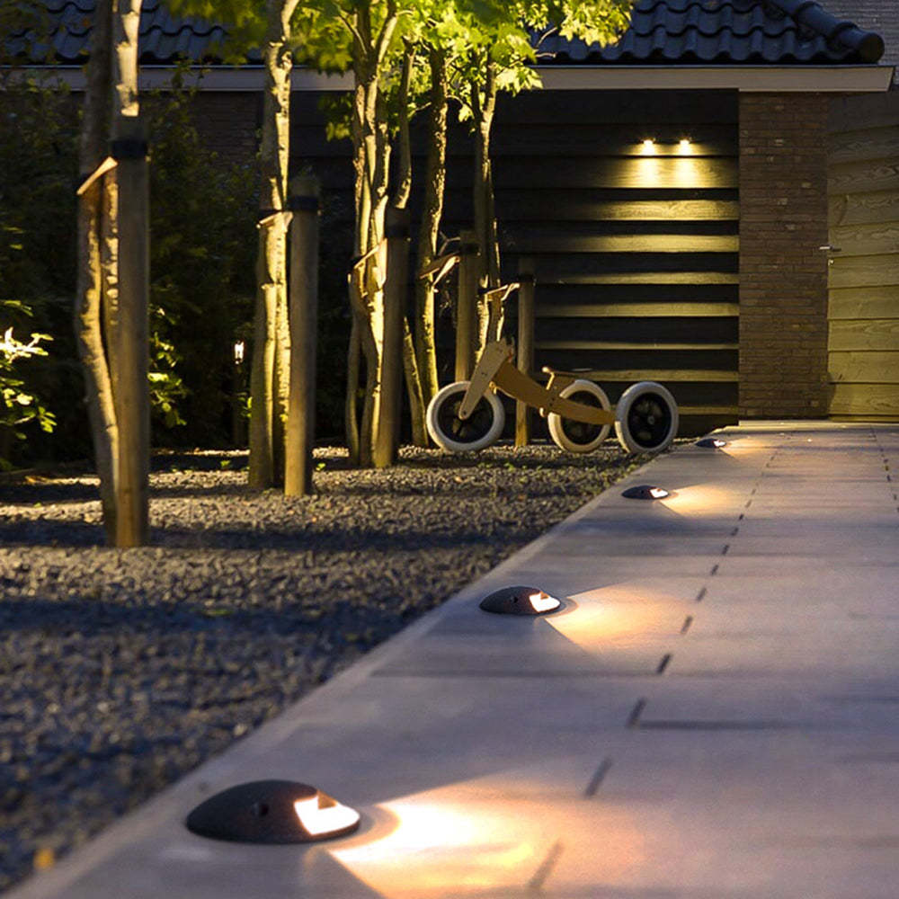 Pena metal outdoor step lights on patio walkway at night.