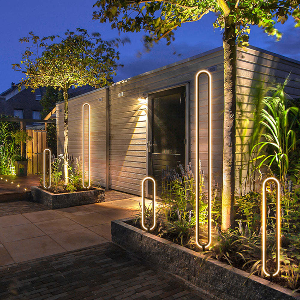 Modern elliptical ring outdoor path lights illuminating a garden