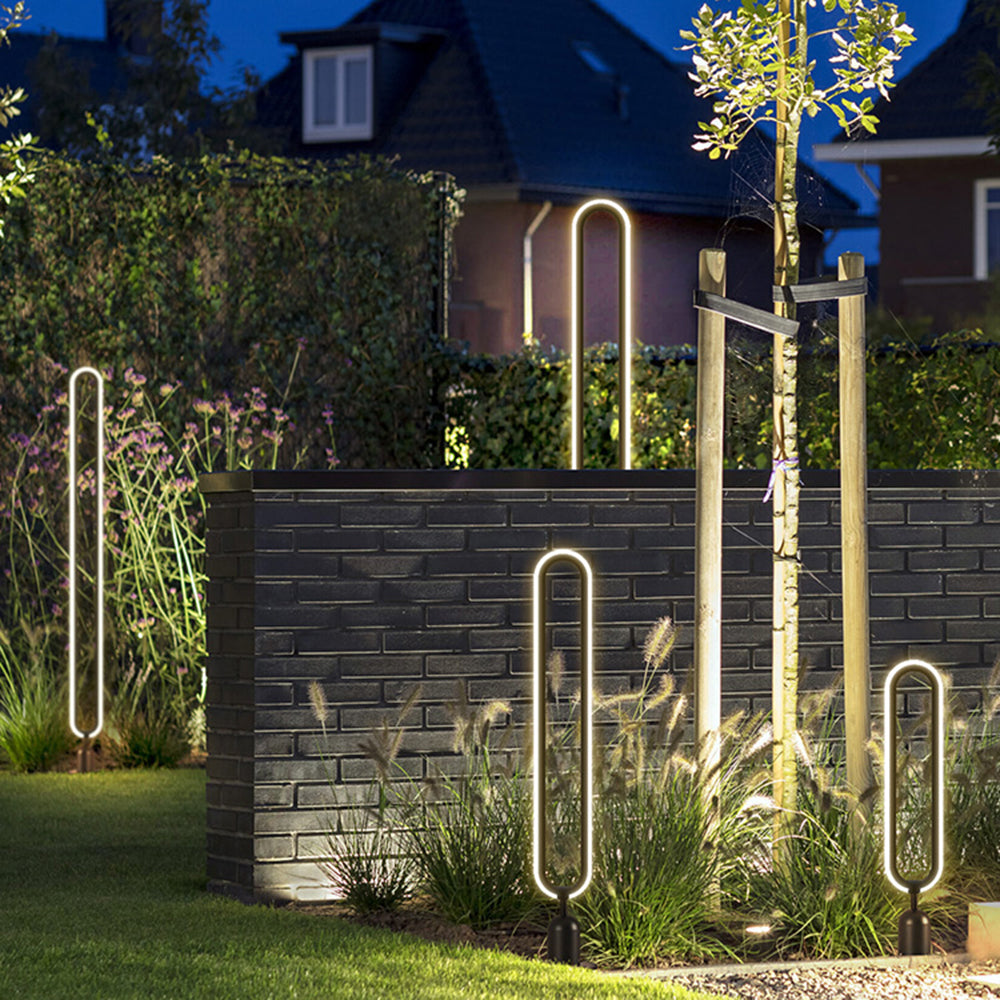 Modernist metal outdoor path lights illuminating a garden at night