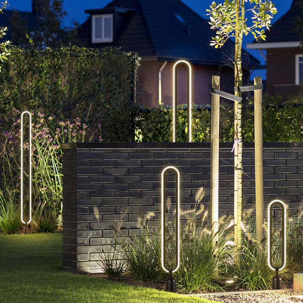Modernist metal outdoor path lights illuminating a garden at night