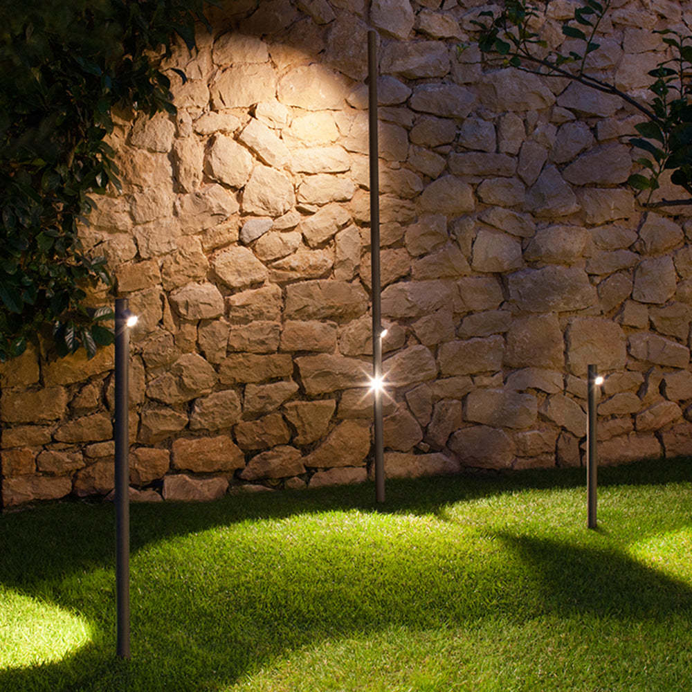 Modern outdoor floor lamps illuminate a garden patio