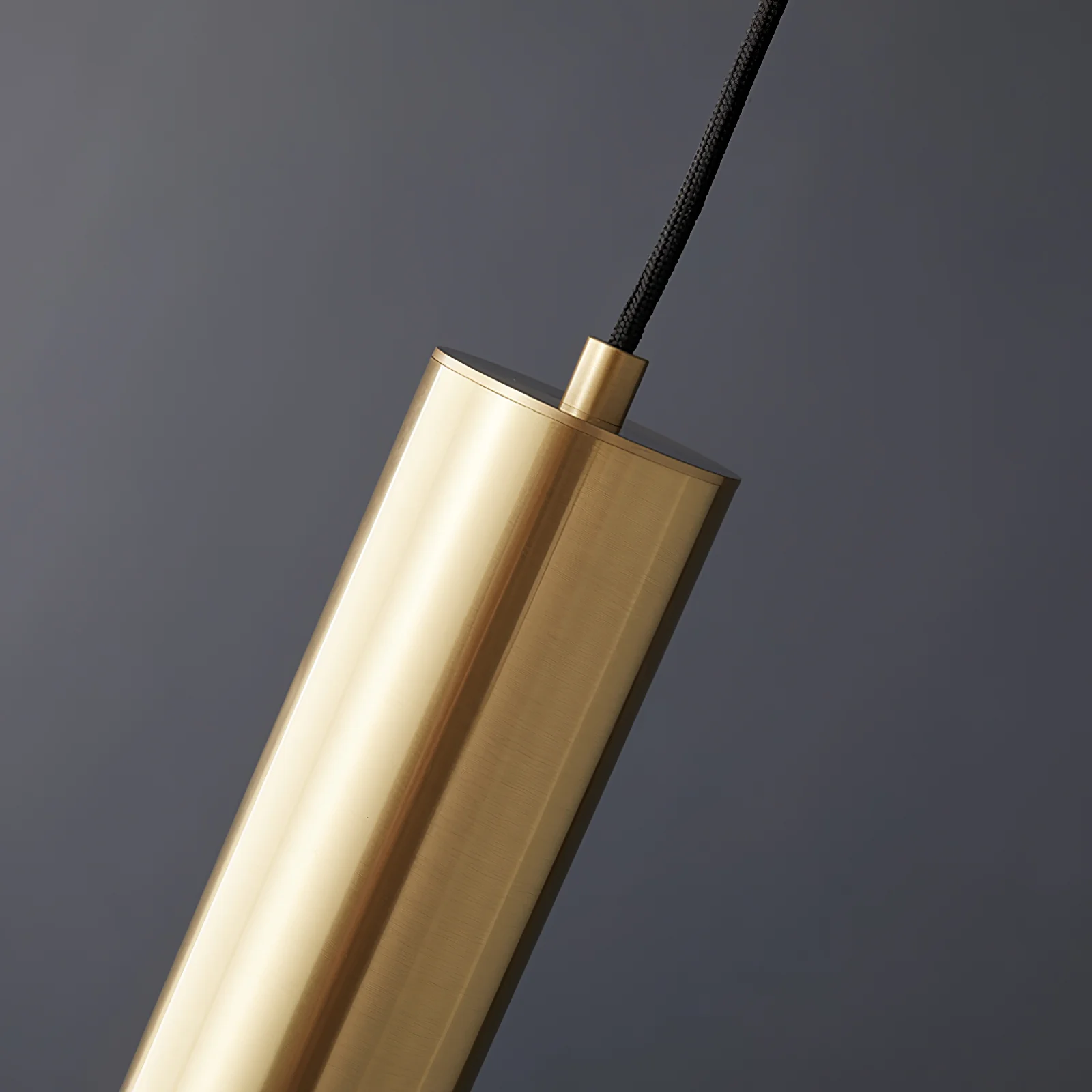 Close-up of gold cylinder pendant light fixture detail.