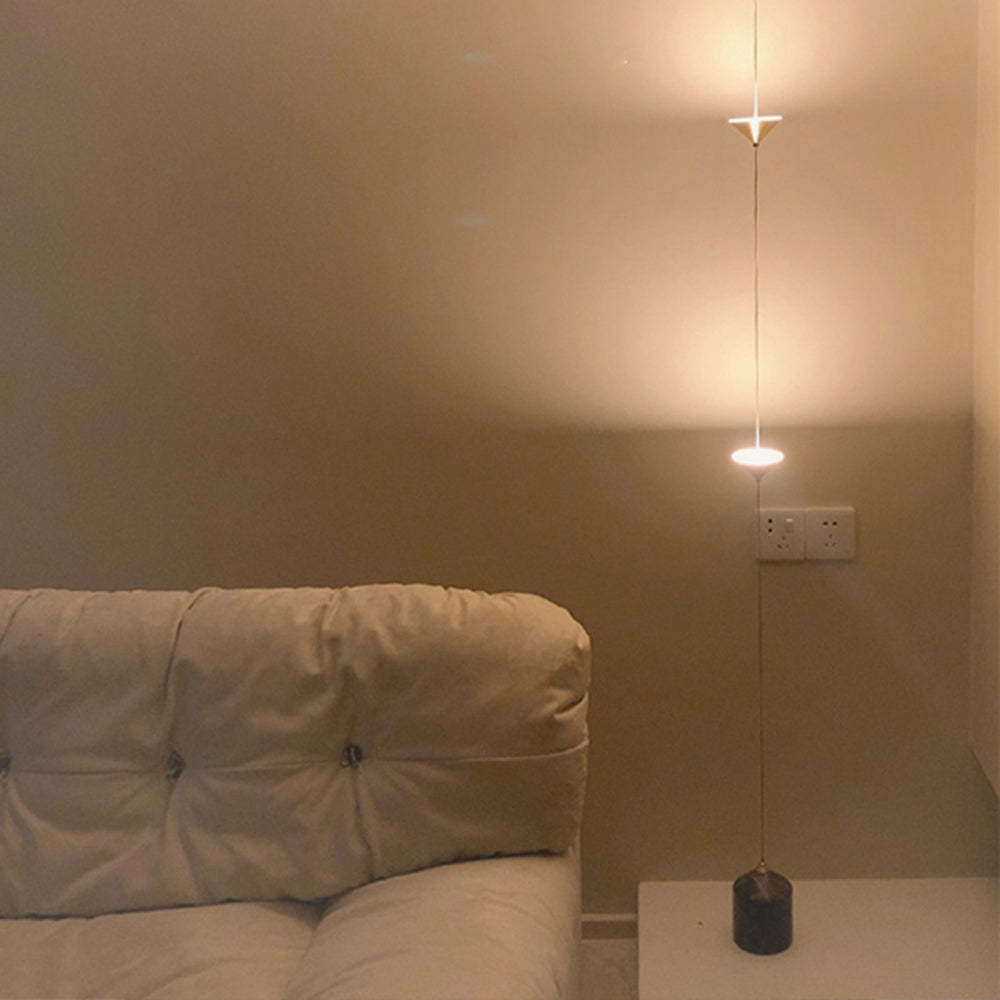 Minimalist LED floor lamp next to a couch