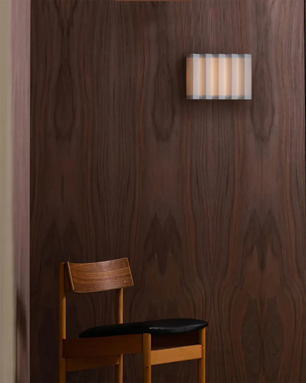 Renee Wall Lamp, chair and wood paneling. Ideal for bedroom lighting