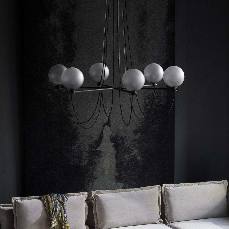 Modern glass ball chandelier over a grey couch in a living room