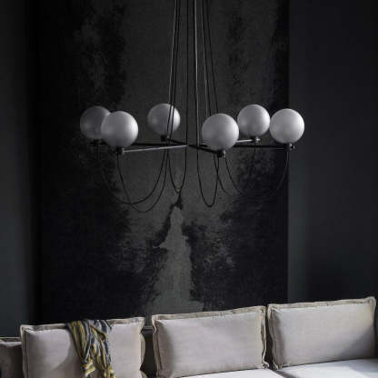 Modern glass ball chandelier over a grey couch in a living room