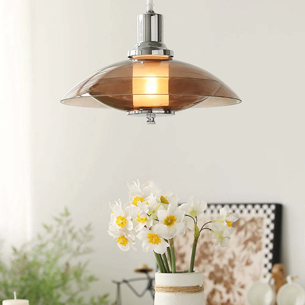 Modern brown glass pendant light over flowers, creating a warm ambience