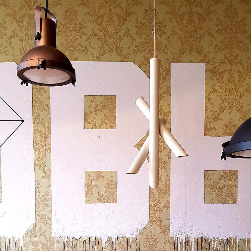 Hailie pendant light with metal tube shape on patterned wall