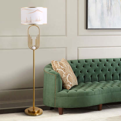 Gold Sano Floor Lamp with Landscape Shade beside green velvet sofa