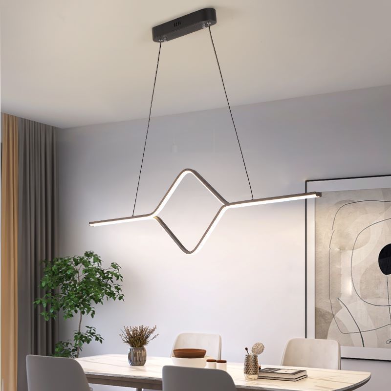 Modern black linear pendant light over dining table.