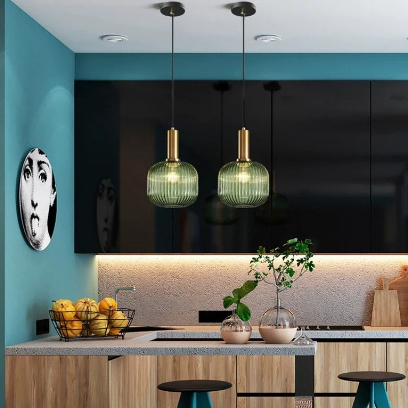 Green Hailie pendant lights over modern kitchen island.