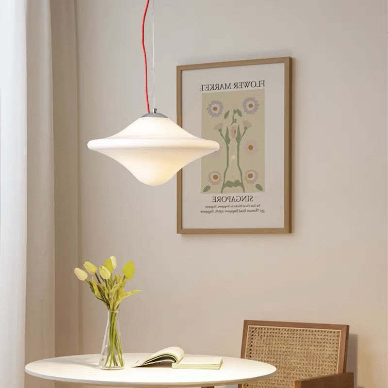 Modern UFO Pendant Light over table with flowers and art