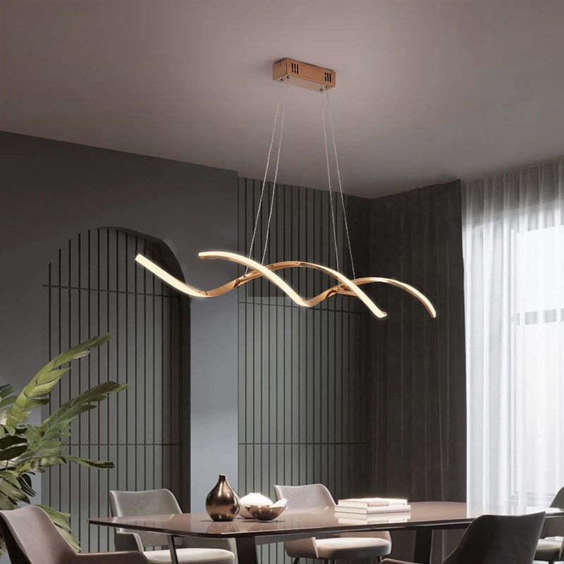 Modern gold wavy pendant light over dining table