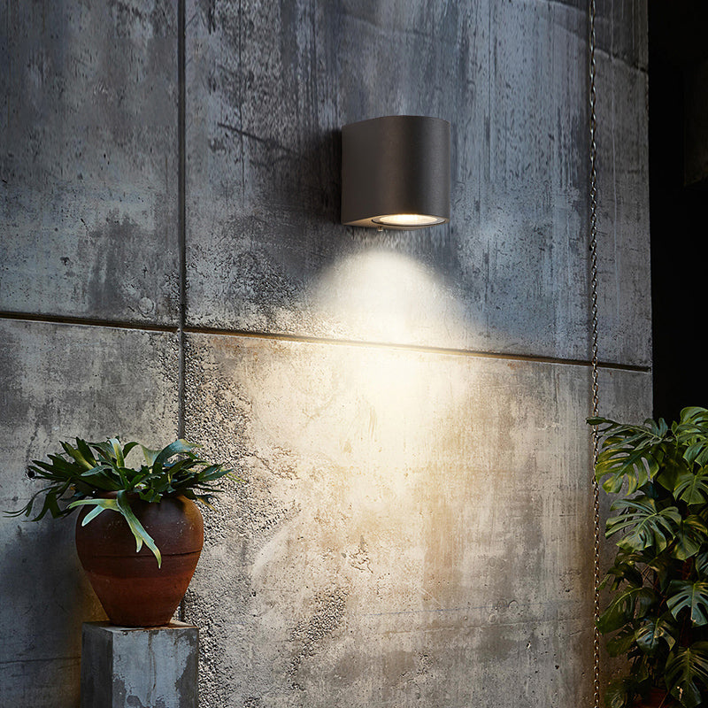 Orr metal outdoor wall lamp illuminating concrete wall.