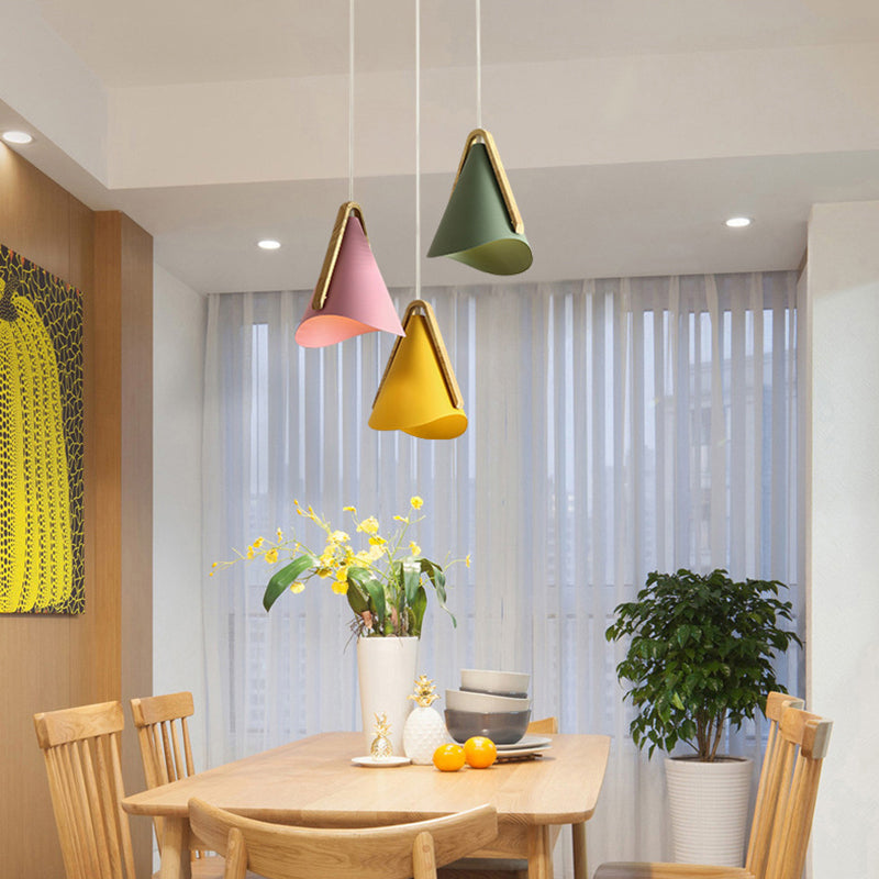 Morandi cone pendant lights above a wooden dining table.