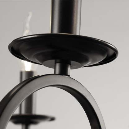 Close-up detail of a black metal chandelier with candle-shaped bulbs