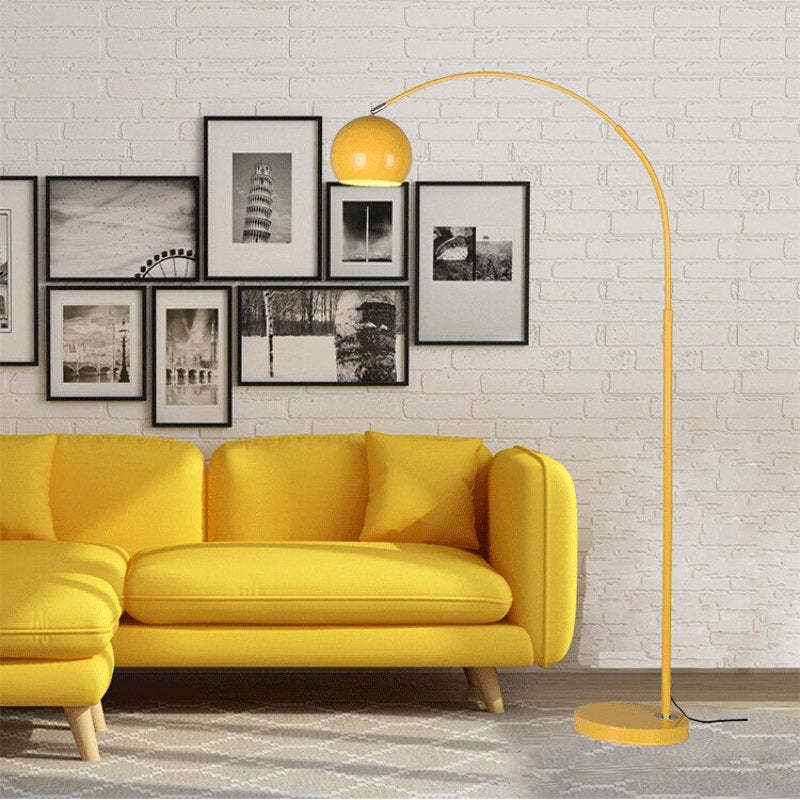 Yellow arc floor lamp next to sofa. Las Sola lighting. Morandi Modern Fishing 1 Light Arc Floor Lamp Metal