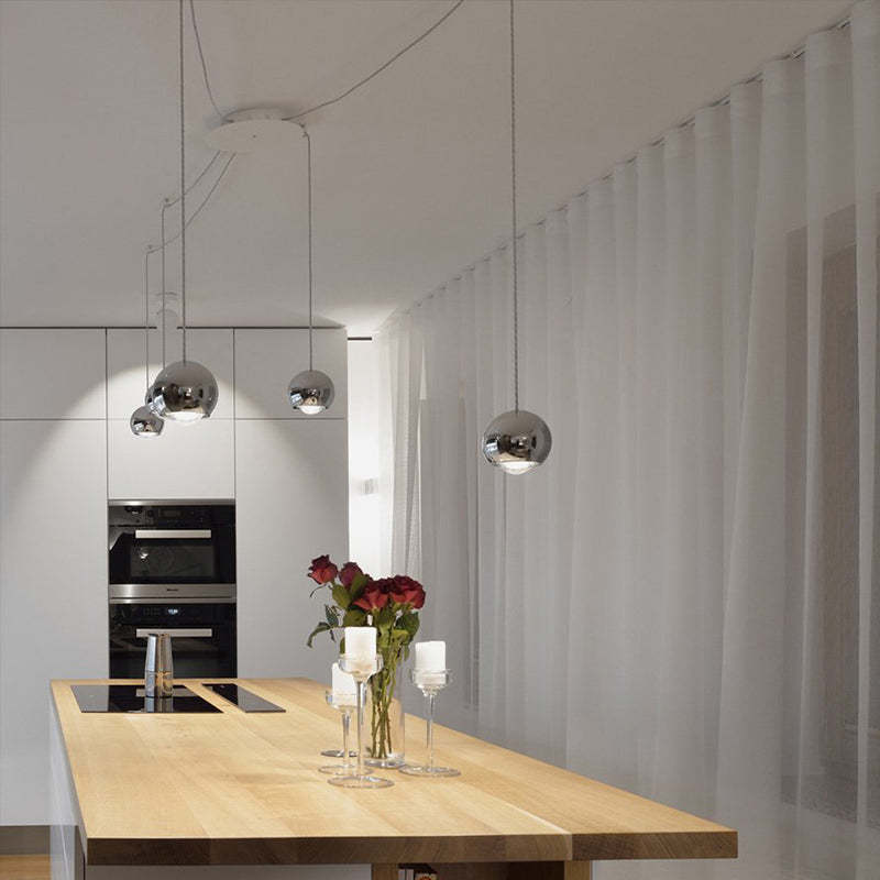 Modern metal ball pendant lights over kitchen island.