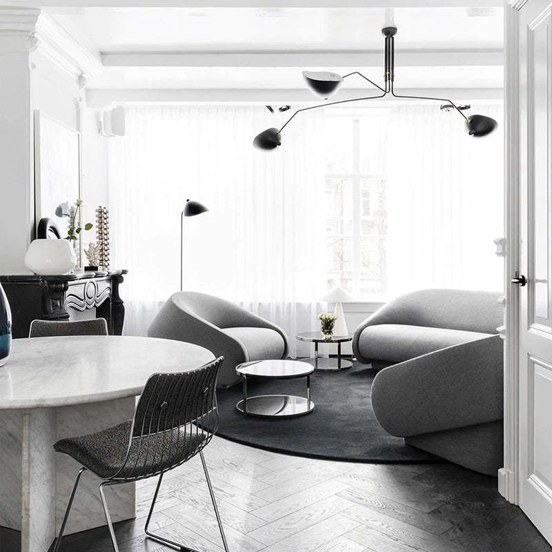 Modern living room with Schmitt pendant light, gray sofas, and marble table