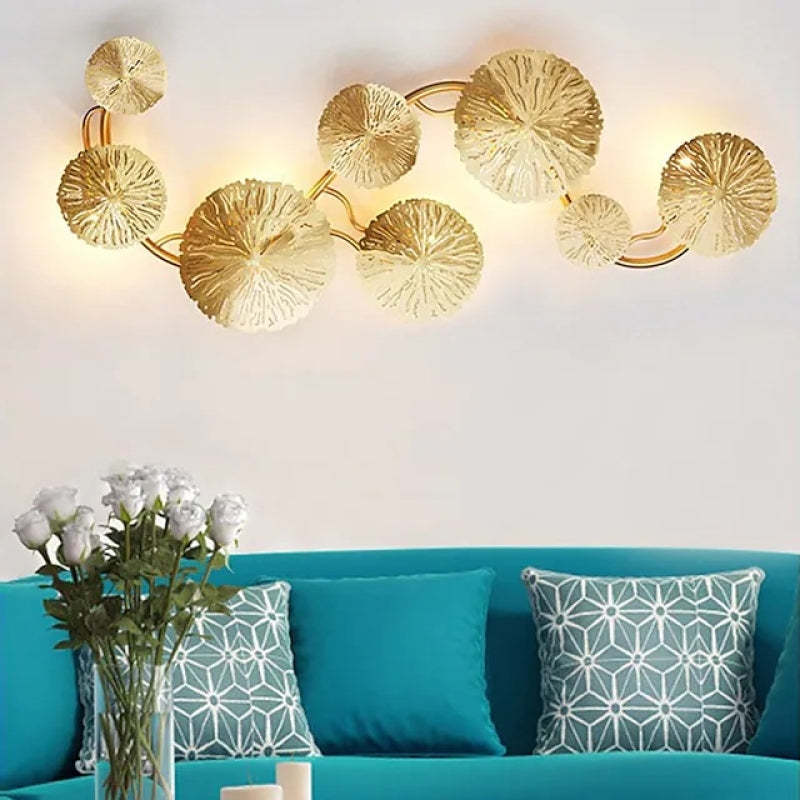 Gold lotus leaf wall lamp above turquoise sofa
