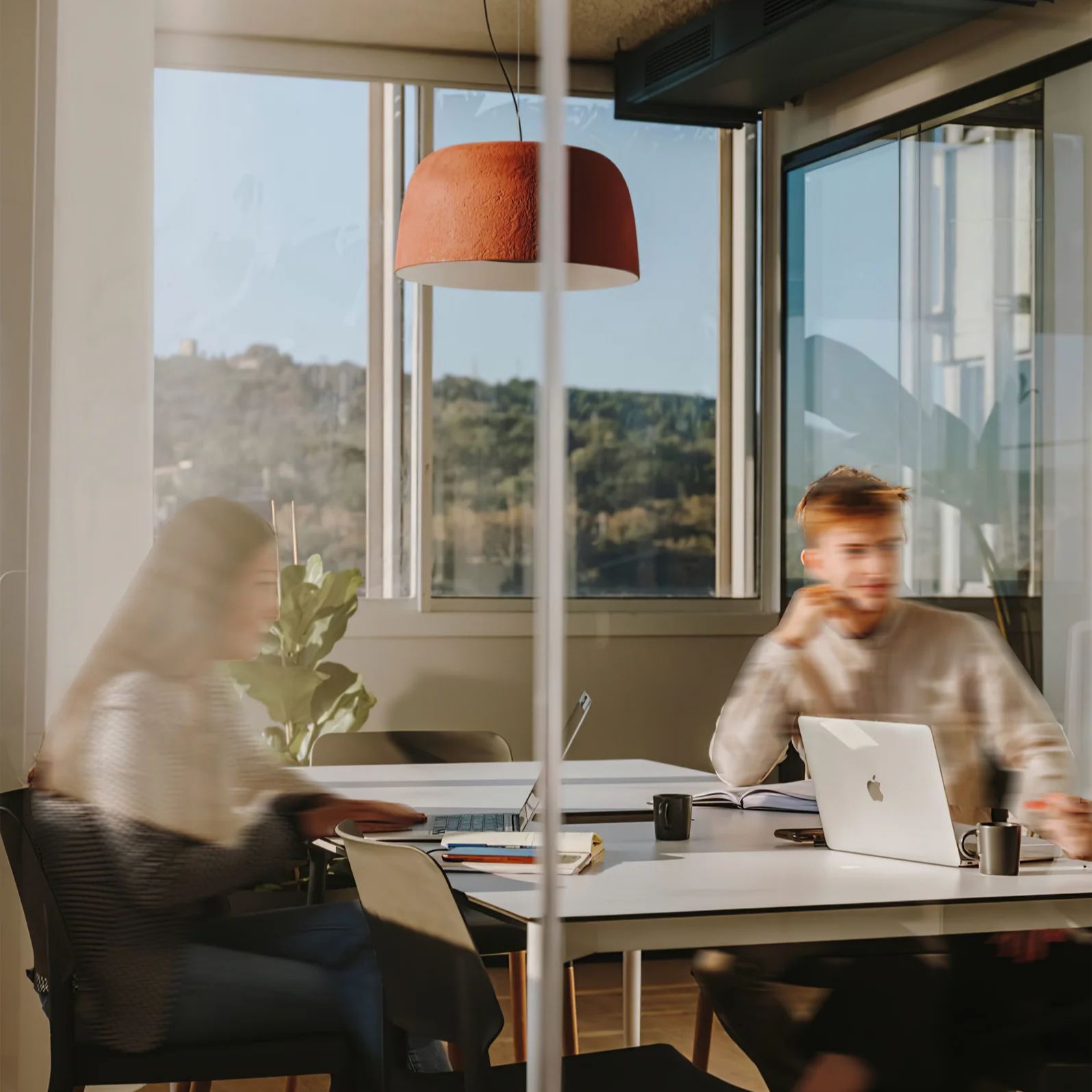 People working in a modern office with a modern round pendant light.