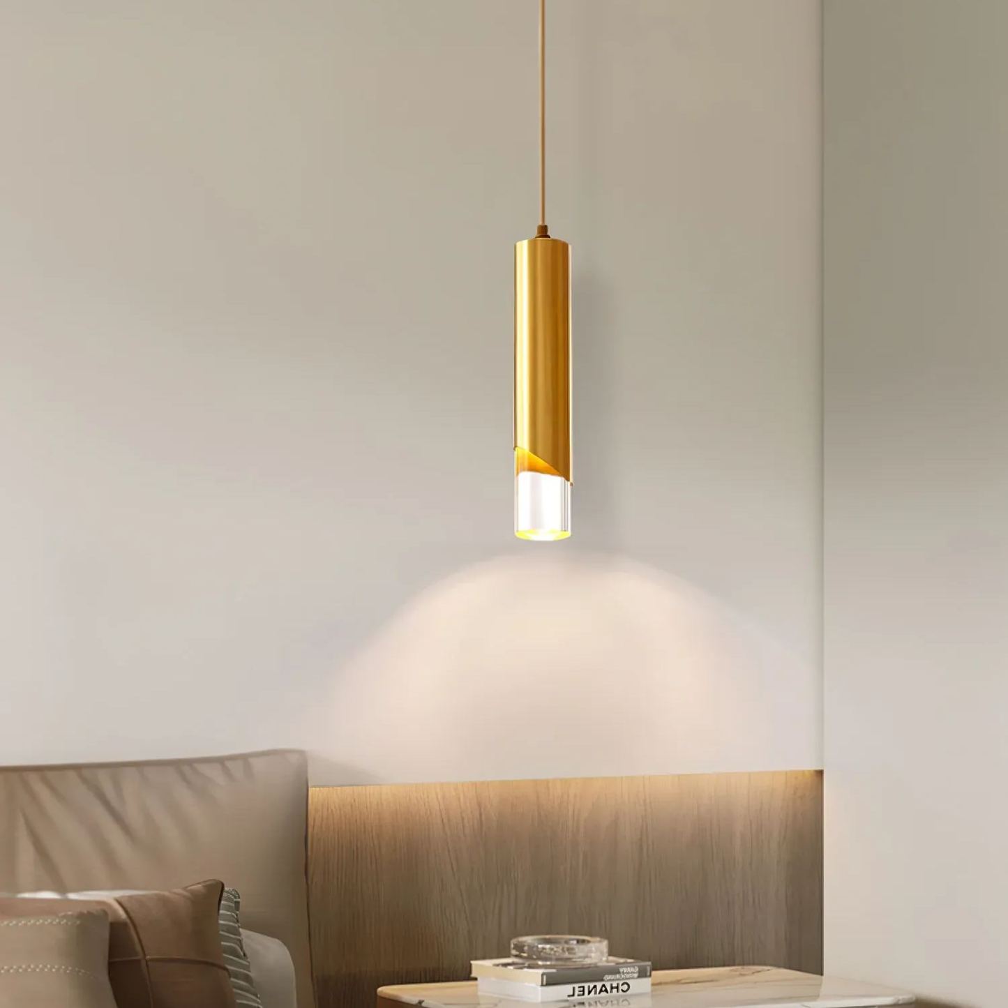 Gold cylinder pendant light in modern bedroom setting