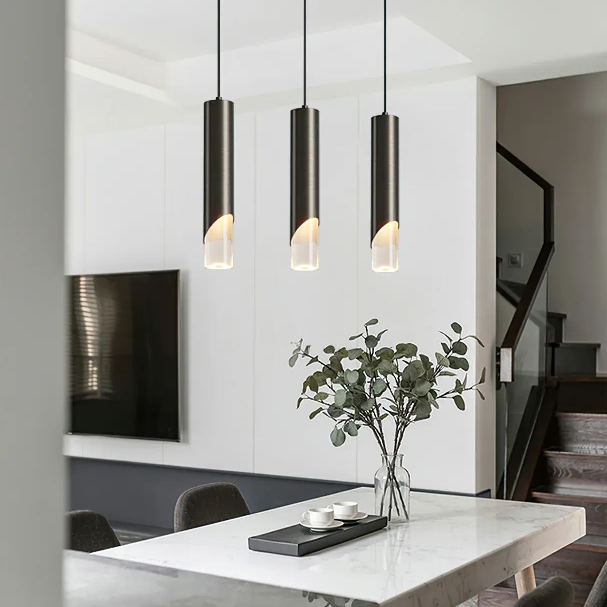 Modern cylinder pendant lights above a dining table