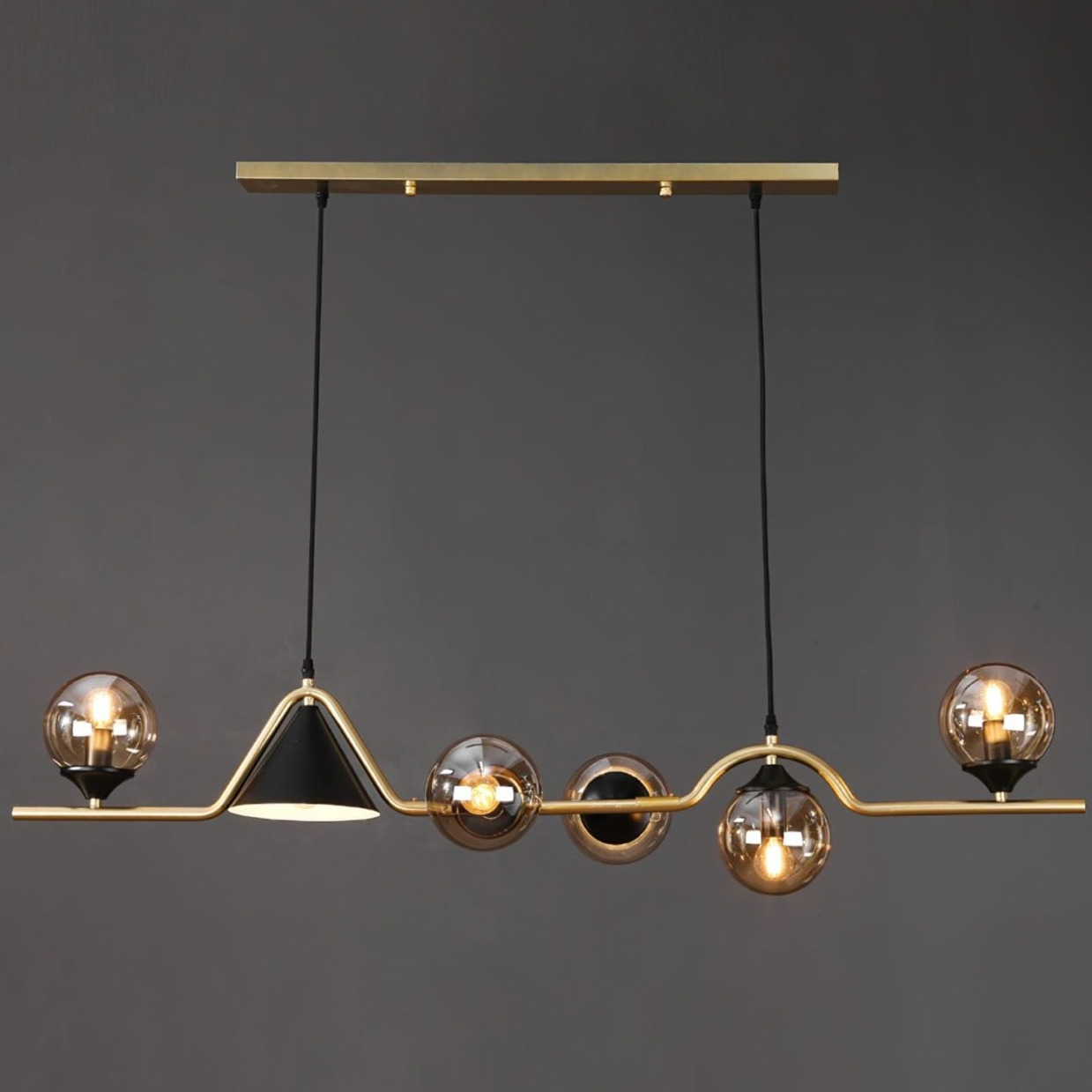 Modern gold pendant light fixture with glass globes and black shade