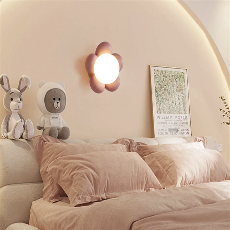 Bedroom decor with flower wall lamp, soft pink bedding and toys